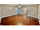 Open living room featuring hardwood floors, ceiling fan, and access to other rooms with an abundance of space at 1820 N Dequincy St, Indianapolis, IN 46218