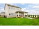 Spacious backyard featuring a covered patio, a fire pit, and lush landscaping at 19840 Chatham Shore Ln, Westfield, IN 46074