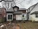 Image of a weathered two-story house undergoing renovations, showing replaced windows and patched siding at 3178 Graceland Ave, Indianapolis, IN 46208