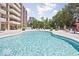 Relaxing community pool surrounded by mature trees and manicured landscaping near a multi-story residential building at 3965 N Meridian St # 7D, Indianapolis, IN 46208