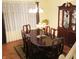 Elegant dining room featuring a wood table set for six, a china cabinet, hardwood floors, and sheer curtains at 5021 Greenside Dr, Indianapolis, IN 46235