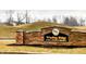 Stone entrance sign to Winding Ridge, a golf course community, with landscaping and a green rolling hillside in the background at 5021 Greenside Dr, Indianapolis, IN 46235