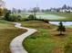 Scenic view of a golf course with a winding sidewalk and a pond on a misty morning at 5021 Greenside Dr, Indianapolis, IN 46235