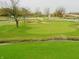 Scenic view of a well-maintained golf course featuring a creek, sand traps, and green grass at 5021 Greenside Dr, Indianapolis, IN 46235