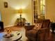 Comfortable living room with hardwood floors, a recliner, a lamp, and double doors leading to another room at 5021 Greenside Dr, Indianapolis, IN 46235