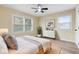 Cozy bedroom with wood-look floors, ceiling fan, and bright natural light from two large windows at 5441 E 34Th St, Indianapolis, IN 46218