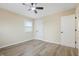 Simple bedroom with wood-look floors, ceiling fan, and a bright window at 5441 E 34Th St, Indianapolis, IN 46218