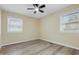 Unfurnished bedroom with wood-look flooring, neutral paint, ceiling fan, and two windows at 5441 E 34Th St, Indianapolis, IN 46218