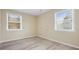 A compact bedroom with wood-look vinyl flooring offers two windows with natural light at 5441 E 34Th St, Indianapolis, IN 46218