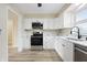 Bright kitchen featuring stainless steel appliances, white cabinets, modern countertops, and laminate flooring at 5441 E 34Th St, Indianapolis, IN 46218
