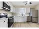 Bright kitchen featuring stainless steel appliances, white cabinets, modern countertop, and laminate flooring at 5441 E 34Th St, Indianapolis, IN 46218