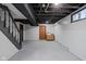 Unfinished basement featuring a staircase, painted walls, and exposed ceiling at 5444 Carrollton Ave, Indianapolis, IN 46220