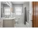 Bright bathroom with tiled walls, a marble countertop vanity, and a shower-tub combination at 5444 Carrollton Ave, Indianapolis, IN 46220