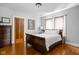 Cozy bedroom with hardwood floors, a decorative dresser, and natural lighting at 5444 Carrollton Ave, Indianapolis, IN 46220