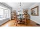 Elegant dining room featuring a glass-top table, hardwood floors, and vintage cabinet at 5444 Carrollton Ave, Indianapolis, IN 46220