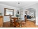 Bright dining room featuring hardwood floors, glass-top table, and seamless flow to living room at 5444 Carrollton Ave, Indianapolis, IN 46220