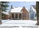Charming brick home featuring arched windows and a snow-covered roof, perfect for winter days at 5444 Carrollton Ave, Indianapolis, IN 46220