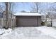 A detached two-car garage with a snow-covered driveway and a wooden fence at 5444 Carrollton Ave, Indianapolis, IN 46220