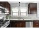 Well-lit kitchen featuring granite countertops, stainless steel appliances, and dark wood cabinets at 5444 Carrollton Ave, Indianapolis, IN 46220