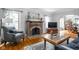 Bright living room with a brick fireplace, hardwood floors, and comfortable chair and television at 5444 Carrollton Ave, Indianapolis, IN 46220