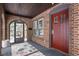 Covered porch with brick accents, front door, and view to the interior at 5444 Carrollton Ave, Indianapolis, IN 46220