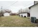 Large backyard with grass, bushes, garage, and an AC unit at 637 N Oakland Ave, Indianapolis, IN 46201