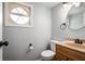 Half bathroom featuring a round mirror, gray walls, and a modern sink at 6629 N 600 W, Fairland, IN 46126