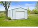 Garage with rolling door and secondary entrance is conveniently located on a well-maintained green lawn at 6629 N 600 W, Fairland, IN 46126