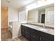 Bathroom featuring a double sink vanity with granite countertop and a soaking tub at 7027 Pinnacle Dr, Columbus, IN 47201