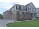 Beautiful home with an attached two car garage, well-maintained lawn, and a charming exterior at 7027 Pinnacle Dr, Columbus, IN 47201