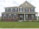 Charming two-story home with brick accents, black shutters, manicured lawn and inviting front porch at 7027 Pinnacle Dr, Columbus, IN 47201