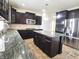 Stylish kitchen boasts granite counters, stainless steel appliances, island, and dark wood cabinetry at 7027 Pinnacle Dr, Columbus, IN 47201