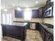 Well-lit kitchen showcasing granite counters, stainless steel appliances, island, and dark cabinetry at 7027 Pinnacle Dr, Columbus, IN 47201