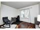 A cozy bedroom features a window, desk, modern chair, and wood-look floors at 7459 Quincy Ct, Indianapolis, IN 46254