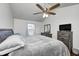 Comfortable bedroom with a ceiling fan, dresser with mirror, TV, and a window providing natural light at 7459 Quincy Ct, Indianapolis, IN 46254