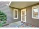 The home's front entrance features shingle siding, a glass door, and a colorful welcome mat at 7459 Quincy Ct, Indianapolis, IN 46254