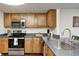 Bright kitchen featuring wooden cabinets, stainless steel appliances, and neutral countertops at 7459 Quincy Ct, Indianapolis, IN 46254