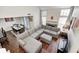 Sunlit living room with modern sofa, fireplace, dining area, and staircase offering a spacious layout at 7459 Quincy Ct, Indianapolis, IN 46254