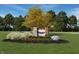 Inviting community entrance featuring stone signage, vibrant flowers, and mature trees under a clear blue sky at 780 James William Ln, Westfield, IN 46074