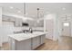Well-lit kitchen featuring an island with seating, stainless steel appliances, gray cabinetry, and sleek countertops at 780 James William Ln, Westfield, IN 46074