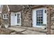 A close-up of the front entrance, featuring stone accents, a chimney, and a well-kept lawn at 8937 W 800 N, Indianapolis, IN 46259
