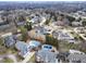 Bird's-eye view of a residential area showcases lush tree coverage, swimming pools, and distinctive home architecture at 12878 Mayfair Ln, Carmel, IN 46032