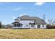 Rear view of a spacious home features a screened porch, deck, and access to the expansive backyard at 12878 Mayfair Ln, Carmel, IN 46032