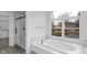 Bright bathroom featuring a soaking tub with a view, and a glass enclosed shower at 12878 Mayfair Ln, Carmel, IN 46032