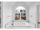 Luxurious bathroom with a soaking tub underneath a large, picturesque window at 12878 Mayfair Ln, Carmel, IN 46032