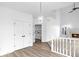 Hallway with neutral decor leads to a well-lit bathroom and cozy fireplace room at 12878 Mayfair Ln, Carmel, IN 46032