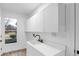 A tidy laundry room featuring modern sink and fixtures with ample cabinetry at 12878 Mayfair Ln, Carmel, IN 46032