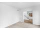 Neutral living room with wainscoting, neutral carpet, and open access to foyer with staircase at 12878 Mayfair Ln, Carmel, IN 46032
