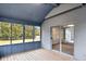 A bright screened-in porch featuring wood flooring and a sliding glass door to the interior at 12878 Mayfair Ln, Carmel, IN 46032