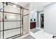 This bathroom features white tiled floors, glass shower door, and modern vanity at 14402 Wolverton Way, Fishers, IN 46037